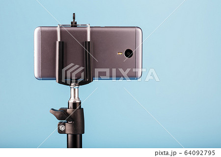 The smartphone is mounted on a tripod as a 64092795