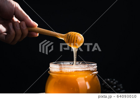 Honey in a glass jar,Scoop the honey in a glass Honey in a glass jar,Scoop the honey in a glass 64093010
