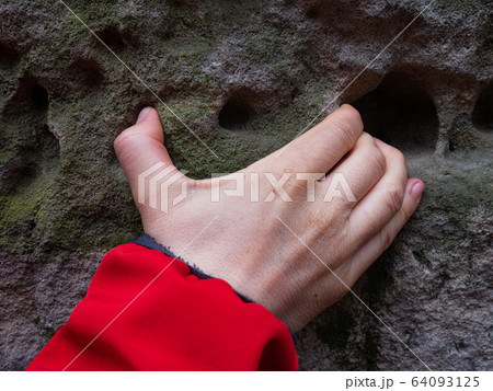 Hand climb on sandstone rock, hold honeycombs 64093125
