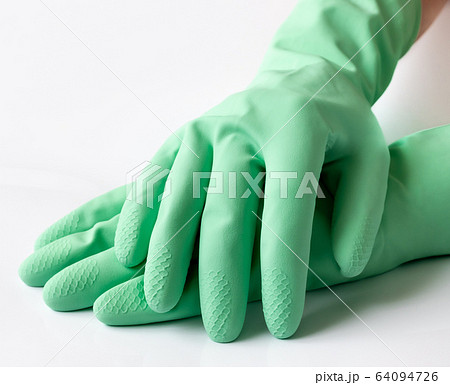 Hand in green latex dishwashing gloves on a white background 64094726