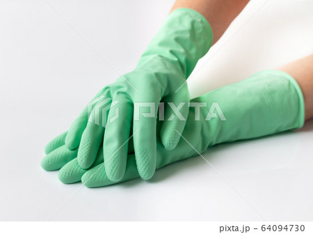 Hand in green latex dishwashing gloves on a white background 64094730