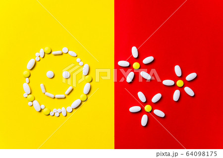 Colored pills, tablets and capsules on a red and yellow background - history of treatment, prevention of pandemic Colored pills, tablets and capsules on a red and yellow background - history of treatment, prevention of pandemic 64098175