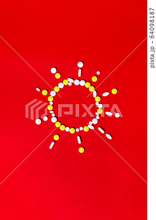 Colored pills, tablets and capsules on a red background - history of treatment, prevention of pandemic 64098187