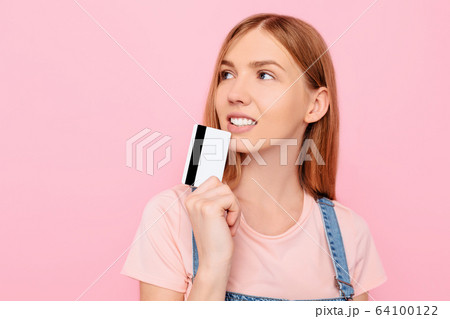 woman showing a credit card and looking into the 64100122