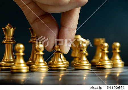 Business man hold pawn to move in chess game Business man hold pawn to move in chess game 64100661