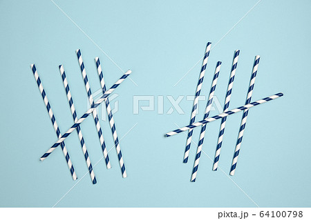 Straws with strips. Monochrome stylish composition in blue color. Top view, flat lay. 64100798