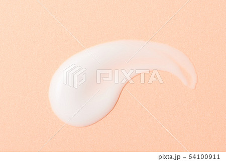 乳液のクローズアップ ペールオレンジの背景 64100911