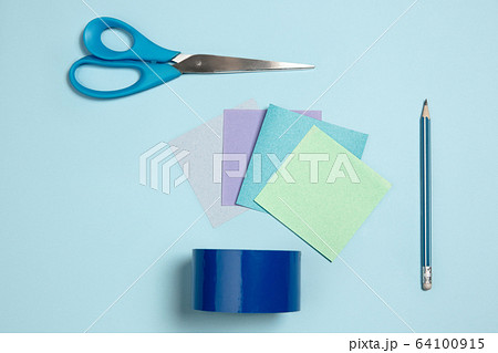 Sticker papers, scissors, pen. Monochrome stylish composition in blue color. Top view, flat lay. 64100915