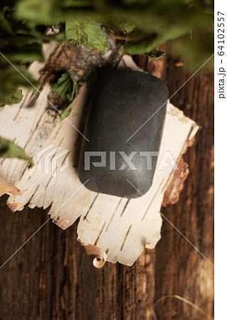 Tar soap lies on birch bark. Aged wooden background, birch leaves. Eco-friendly body care, disease protection. Personal hygiene. Top view 64102557