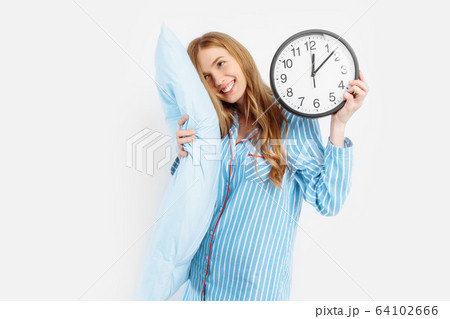 Happy girl dressed in her pajamas, holding the Happy girl dressed in her pajamas, holding the 64102666