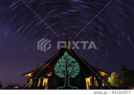 Night View of Wat Sirindhorn Wararam Phu Prao, Glow in the Dark Temple under the long exposure star trail rotation, Ubon Ratchathani, Thailand 64102877