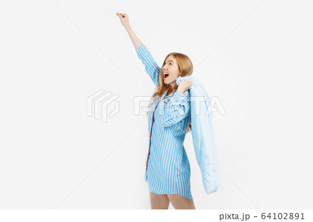 Attractive happy girl in pajamas, with pillow in 64102891