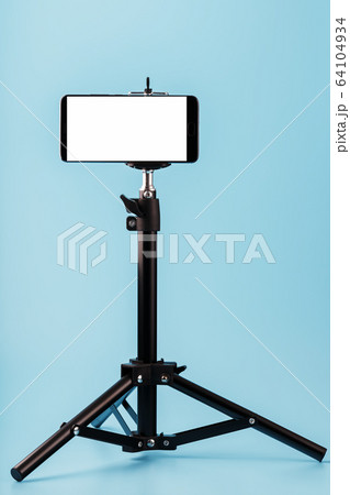 Mobile phone mounted on a tripod with a white 64104934
