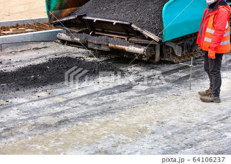 The large paver is filled with hot asphalt The large paver is filled with hot asphalt 64106237