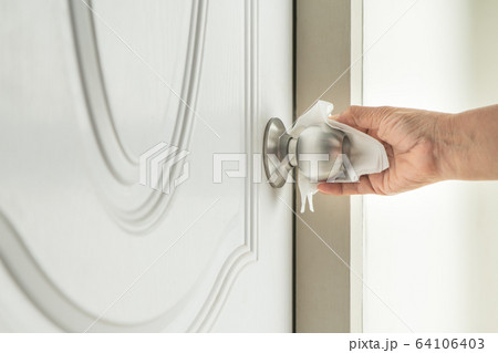 Cleaning door knob with alcohol spray for Covid-19 Coronavirus prevention 64106403