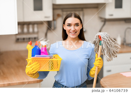 Young woman holding mop and bucket with detergents Young woman holding mop and bucket with detergents 64106739