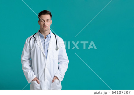 Serious handsome doctor with stethoscope, hands in pocket Serious handsome doctor with stethoscope, hands in pocket 64107207