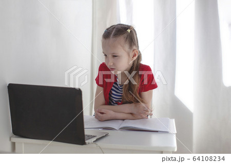 7 year old girl studying online. Webinar. Back to school. 7 year old girl studying online. Webinar. Back to school. 64108234