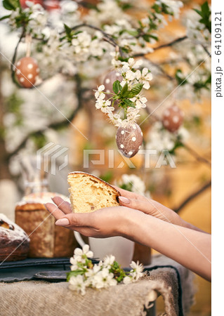 Traditional russian Easter. Woman hands take Orthodox paskha, kulich cakes on table. Traditional russian Easter. Woman hands take Orthodox paskha, kulich cakes on table. 64109121