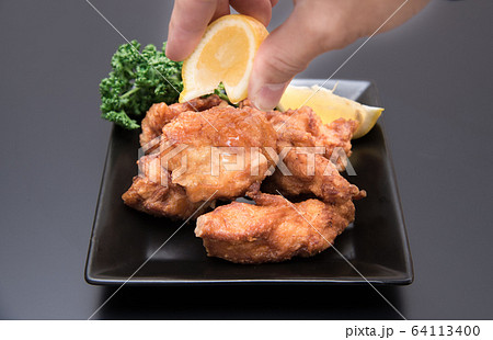 鶏の唐揚げにレモンをかける男性の手元 鶏の唐揚げにレモンをかける男性の手元 64113400