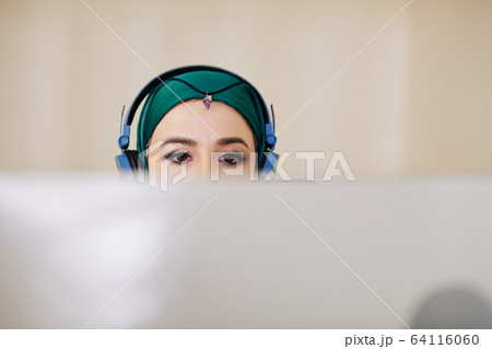 Muslim woman working on computer Muslim woman working on computer 64116060