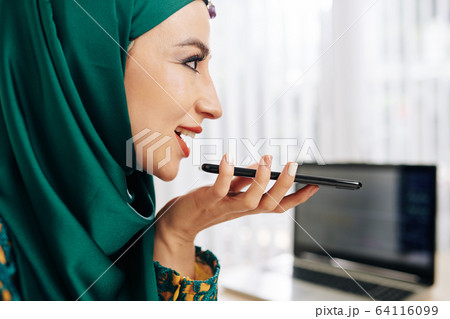 Businesswoman recording voice message Businesswoman recording voice message 64116099