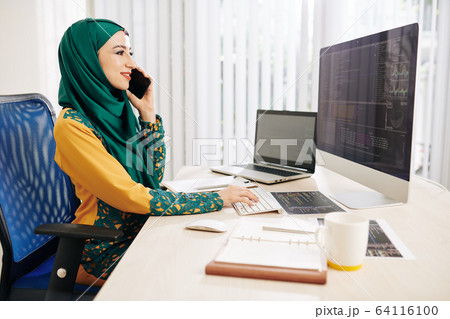 Muslim software developer talking on phone Muslim software developer talking on phone 64116100