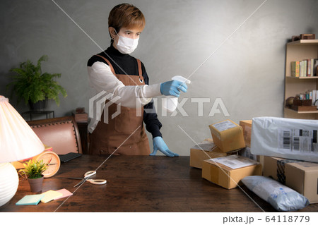 A person spraying disinfectant 64118779