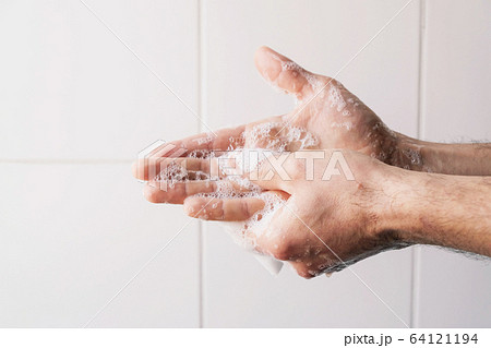 Man cleaning his hands using liquid disinfectant soap. 64121194