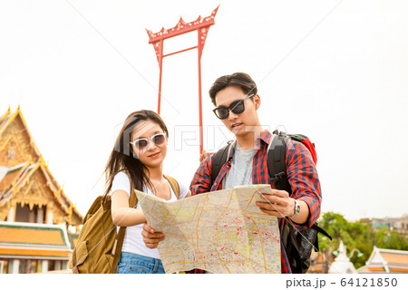 Asian tourist couple with map traveling in Bangkok Thailand Asian tourist couple with map traveling in Bangkok Thailand 64121850