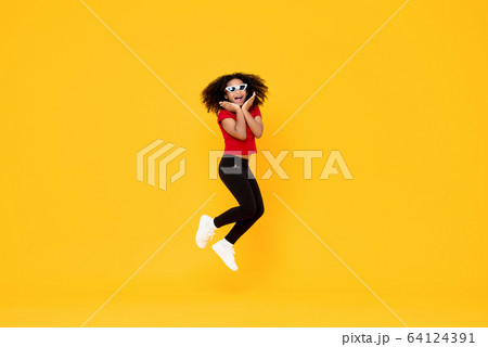 Happy fashionable African American girl jumping 64124391