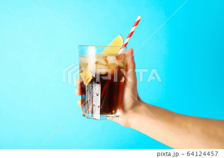 Female hand holding a glass with ice cola, tubule Female hand holding a glass with ice cola, tubule 64124457