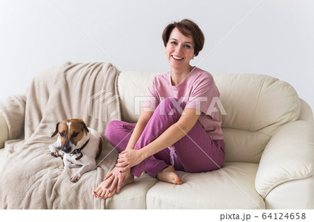 Young attractive woman dressed in beautiful colorful pajama posing as a model in her living room. Comfortable sleepwear, home relaxation and female fashion concept. Young attractive woman dressed in beautiful colorful pajama posing as a model in her living room. Comfortable sleepwear, home relaxation and female fashion concept. 64124658