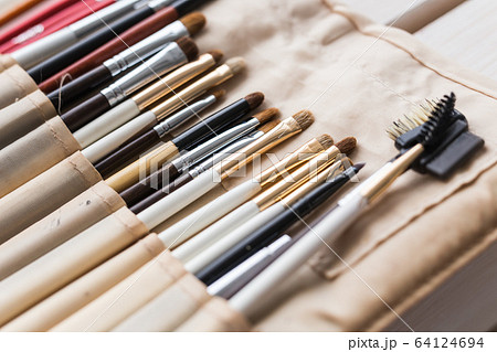 Makeup, beauty and cosmetics concept - Set of make-up brushes in a light case. 64124694