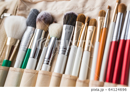 Makeup, beauty and cosmetics concept - Set of make-up brushes in a light case. 64124696