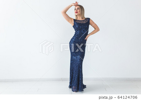Fashionable young blonde woman in beautiful summer dress posing at white studio. 64124706