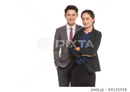 Two business people standing and posing.. Two business people standing and posing.. 64125438