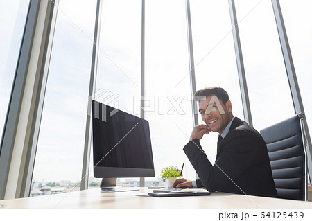 Businessman support the chin and using computer.. Businessman support the chin and using computer.. 64125439