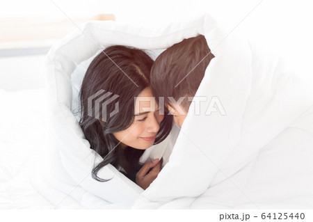 Couple lie prone and put blanket cover their Couple lie prone and put blanket cover their 64125440