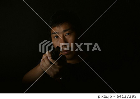 Asian murderer man aiming gun to victim, Suspect preparing to shoot. Asian murderer man aiming gun to victim, Suspect preparing to shoot. 64127295