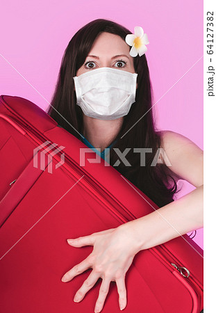 Frightened tourist woman in a medical mask presses Frightened tourist woman in a medical mask presses 64127382