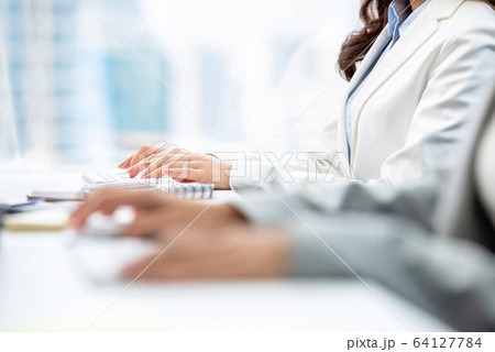 Hands of woman white collar workers typing on computer keyboards Hands of woman white collar workers typing on computer keyboards 64127784
