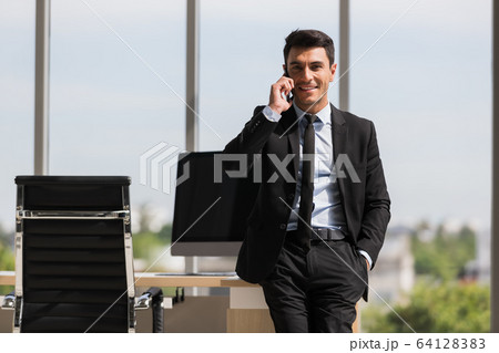 Businessman stands and using smartphone.. 64128383
