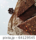 A pieces of chocolate brownie on a crumpled paper with bokeh lights 64129545