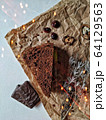 A piece of brownie and chocolate candies on a crumpled paper with bokeh lights 64129563