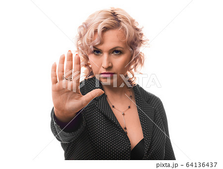 Middle aged businesswoman showing stop sign with palm of hand. Middle aged businesswoman showing stop sign with palm of hand. 64136437