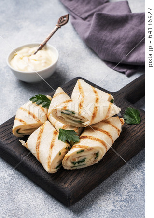 Roll with cheese and herbs. Grilled pita bread Roll with cheese and herbs. Grilled pita bread 64136927