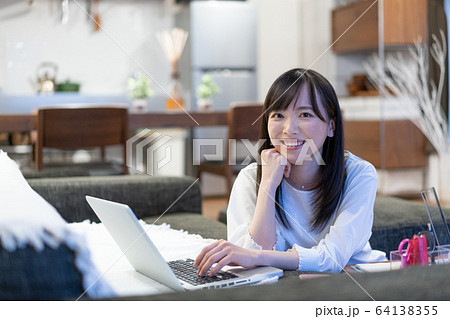 自宅でパソコンをする若い女性 自宅でパソコンをする若い女性 64138355