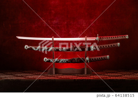 Three swords on stand, katana blade exposed, red Three swords on stand, katana blade exposed, red 64138515