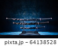 Three swords on stand, with dramatic blue light 64138528